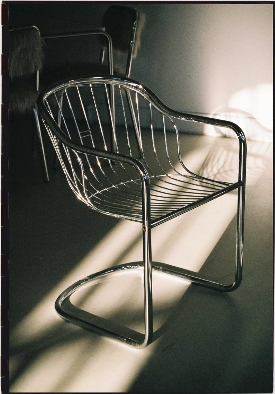 A chrome cantilever chair catching the studio daylight