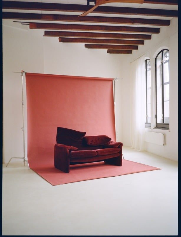 Vintage sofa on a coral seamless backdrop by the warehouse windows