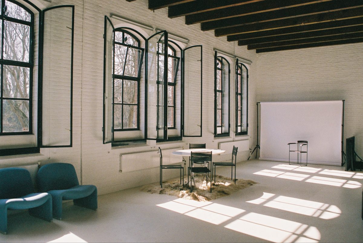 A bright corner of the studio with the original arched warehouse windows