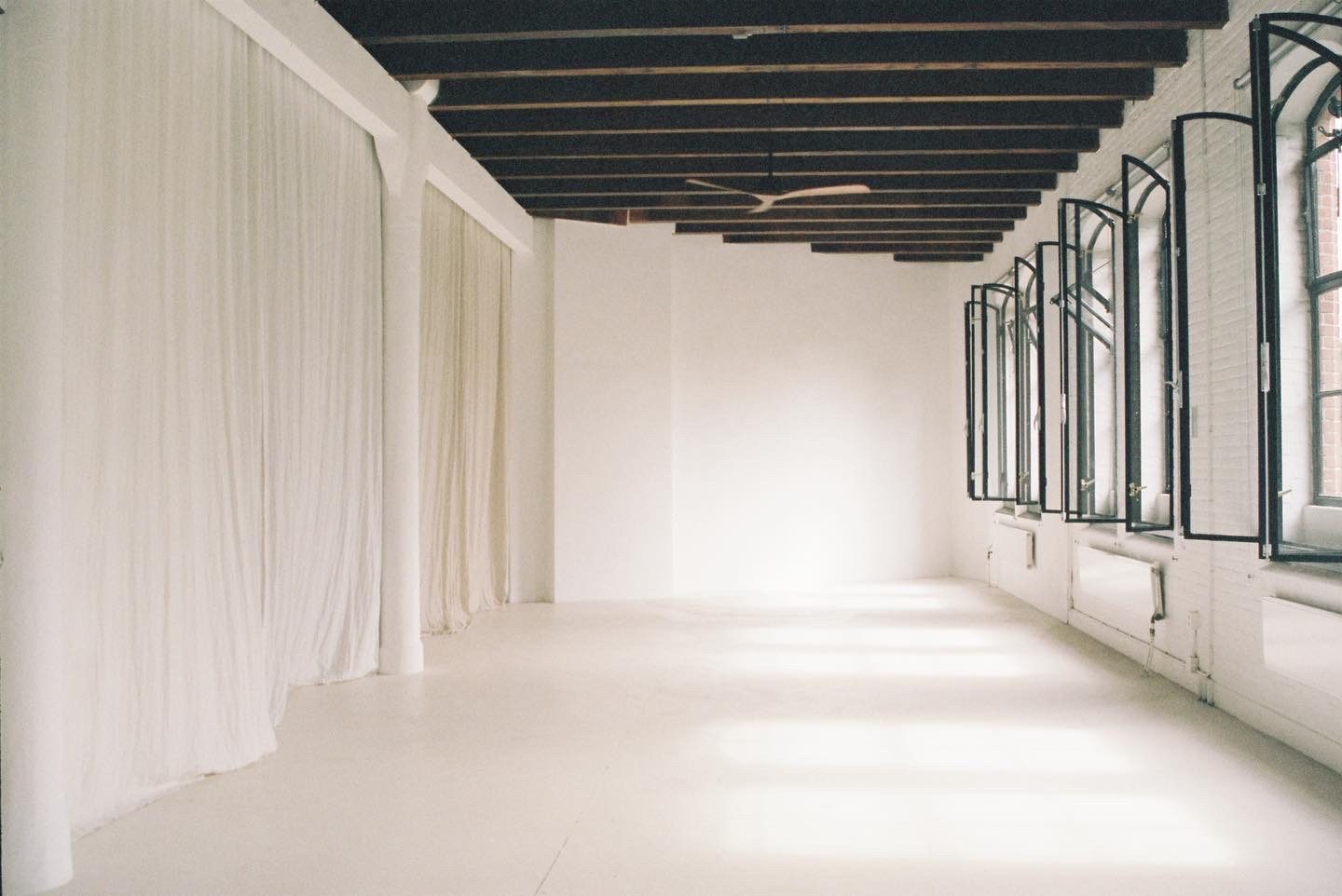 The open shoot space — white floor, daylight and clothing rack